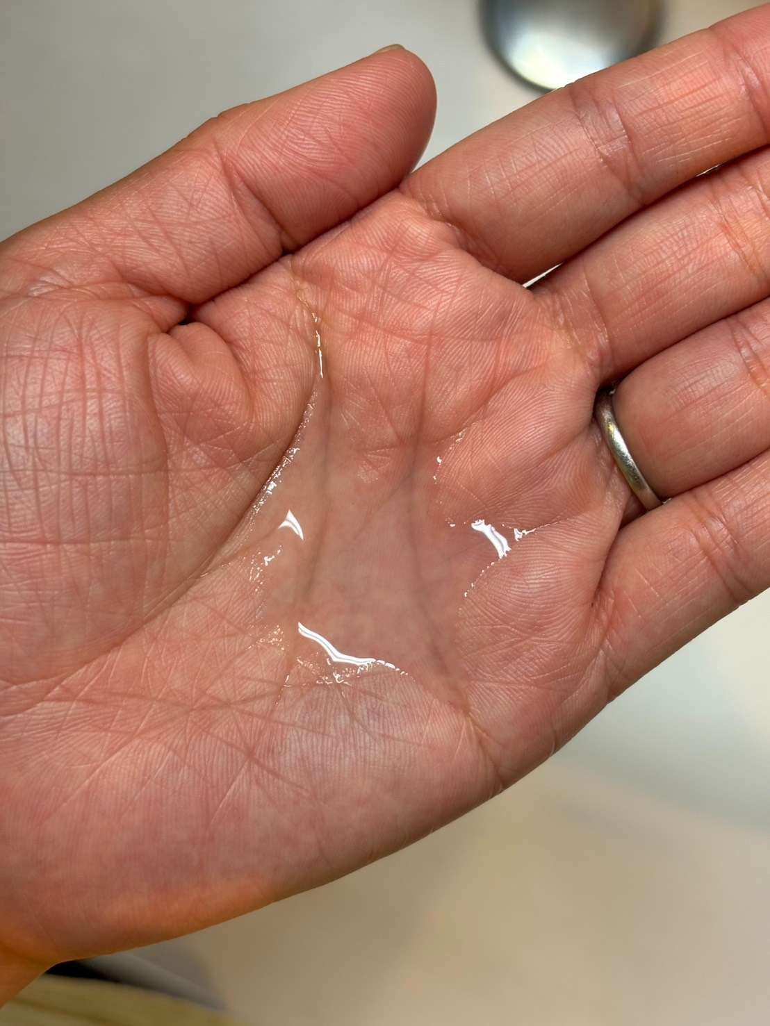 手のひらに出している、透明でみずみずしい化粧液の写真