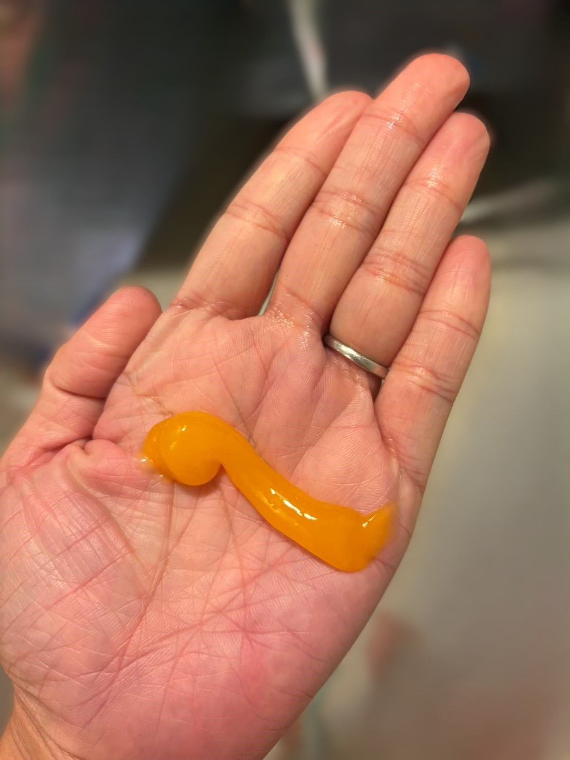 マナラ ホットクレンジングゲル マッサージプラスのオレンジ色ゲルを手のひらに乗せている